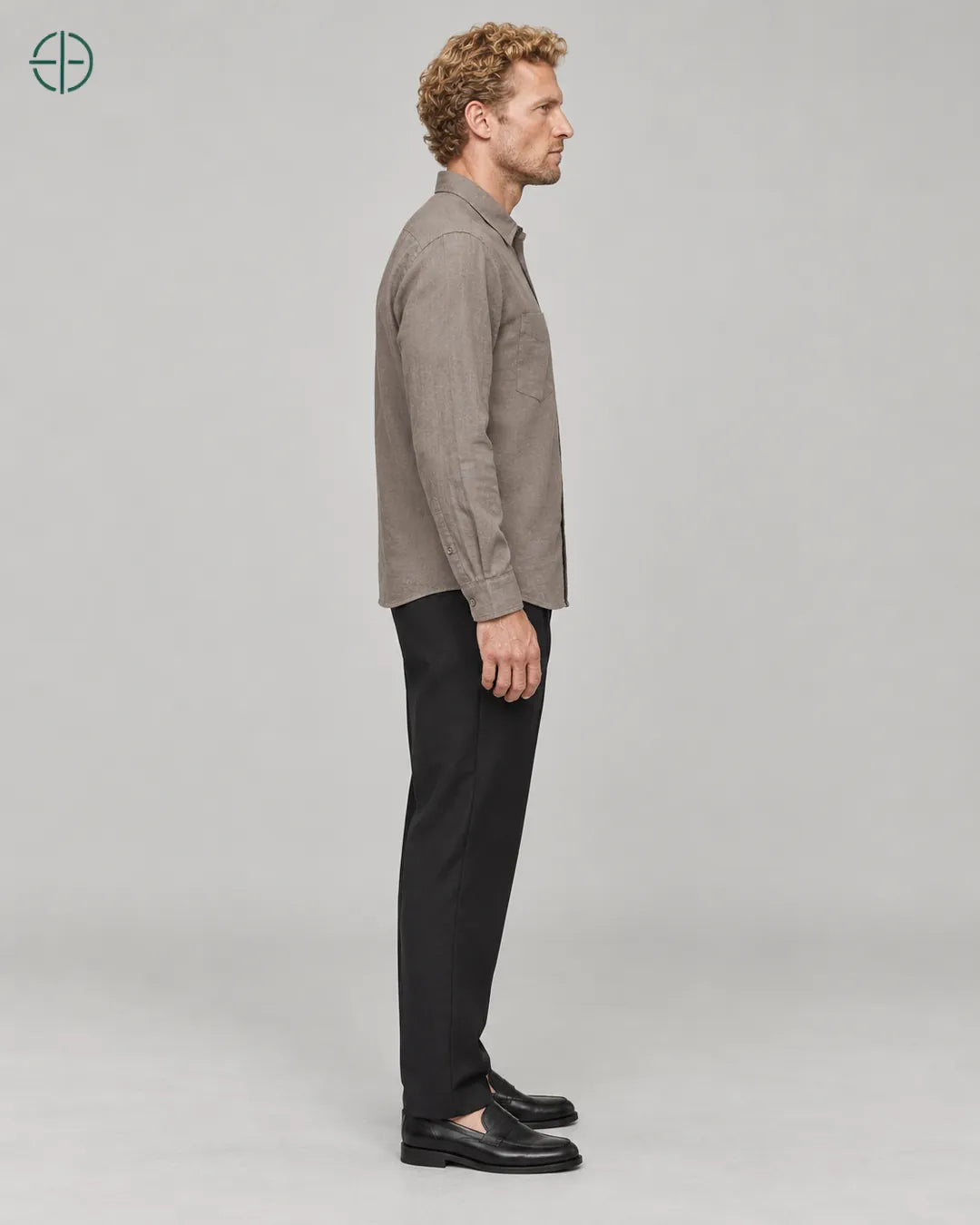 Camisa 100% Linho Belga Masculina, cor Camelo, mesmo modelo e roupa de lado, em estúdio profissional com fundo cinza ostra.