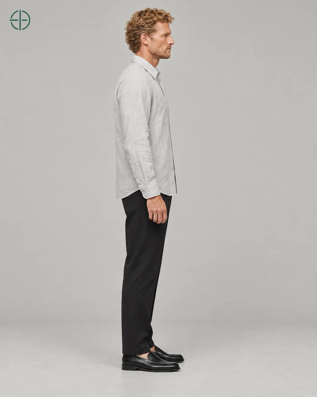 Camisa 100% Linho Belga Masculina, cor Cinza, mesmo modelo e roupa de lado, em estúdio profissional com fundo cinza ostra.
