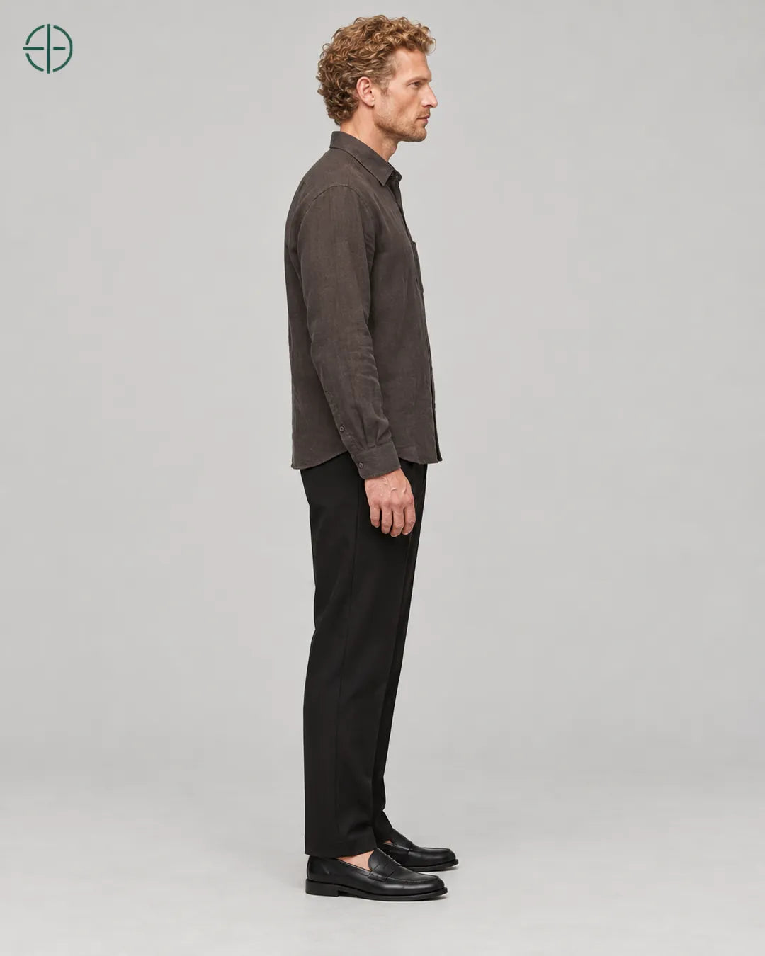 Camisa 100% Linho Belga Masculina, cor Marrom, mesmo modelo e roupa de lado, em estúdio profissional com fundo cinza ostra.