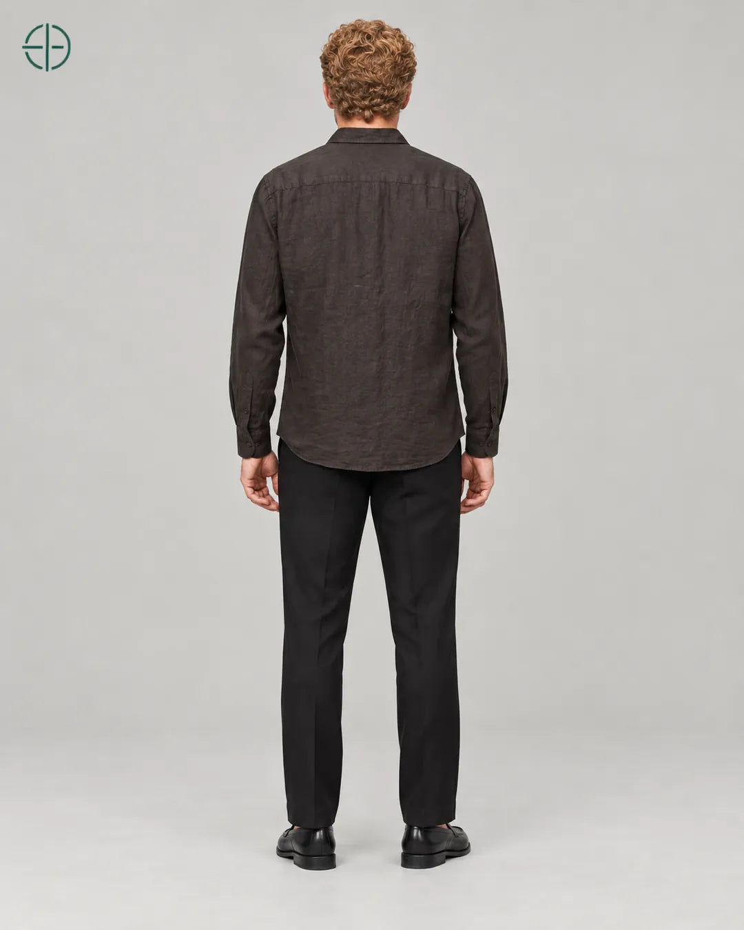 Camisa 100% Linho Belga Masculina, cor Marrom, mesmo modelo e roupa de costas, em estúdio profissional com fundo cinza ostra.