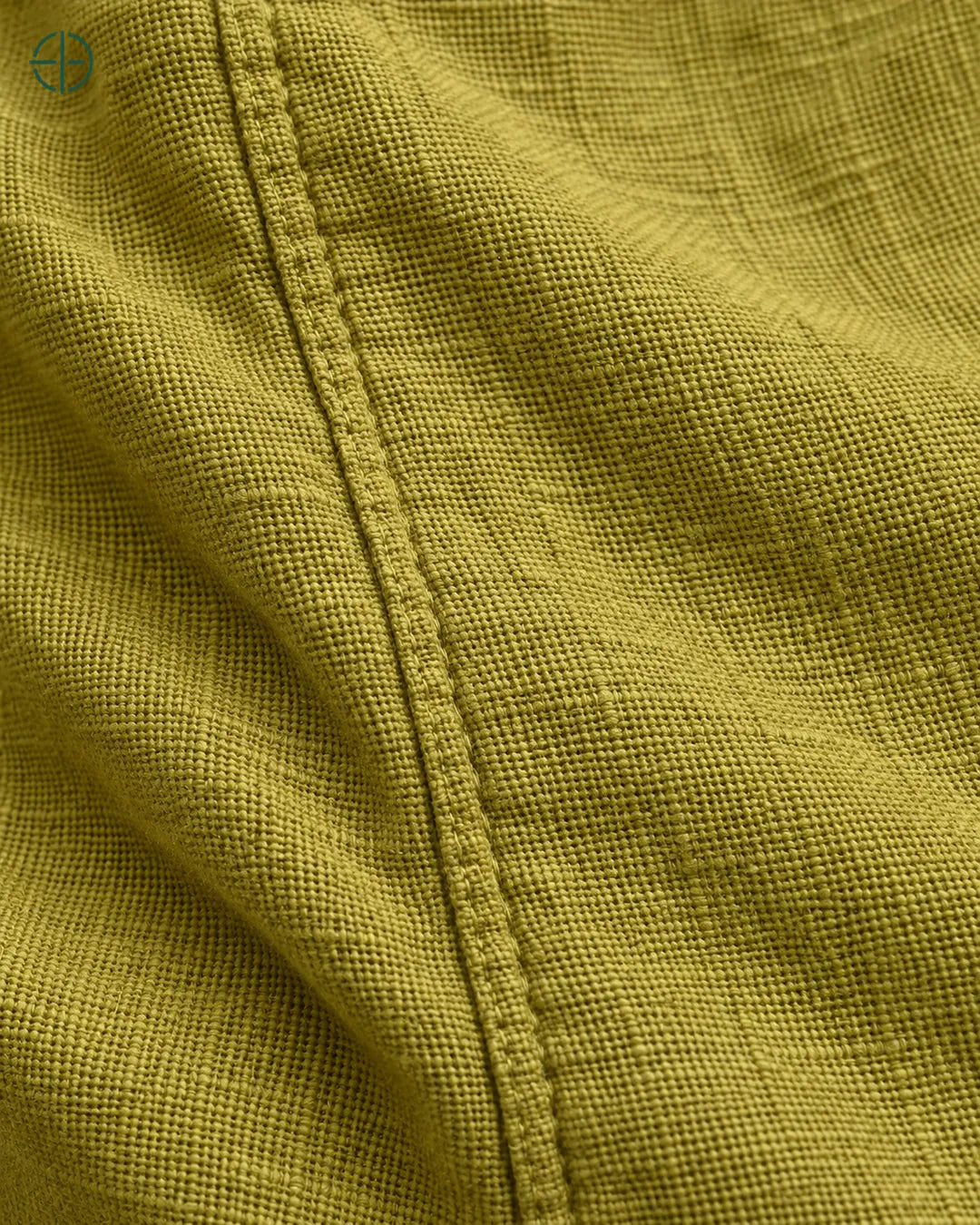 Camisa 100% Linho Belga Masculina, cor Oliva, macro do produto no modelo, em estúdio profissional com fundo cinza ostra.