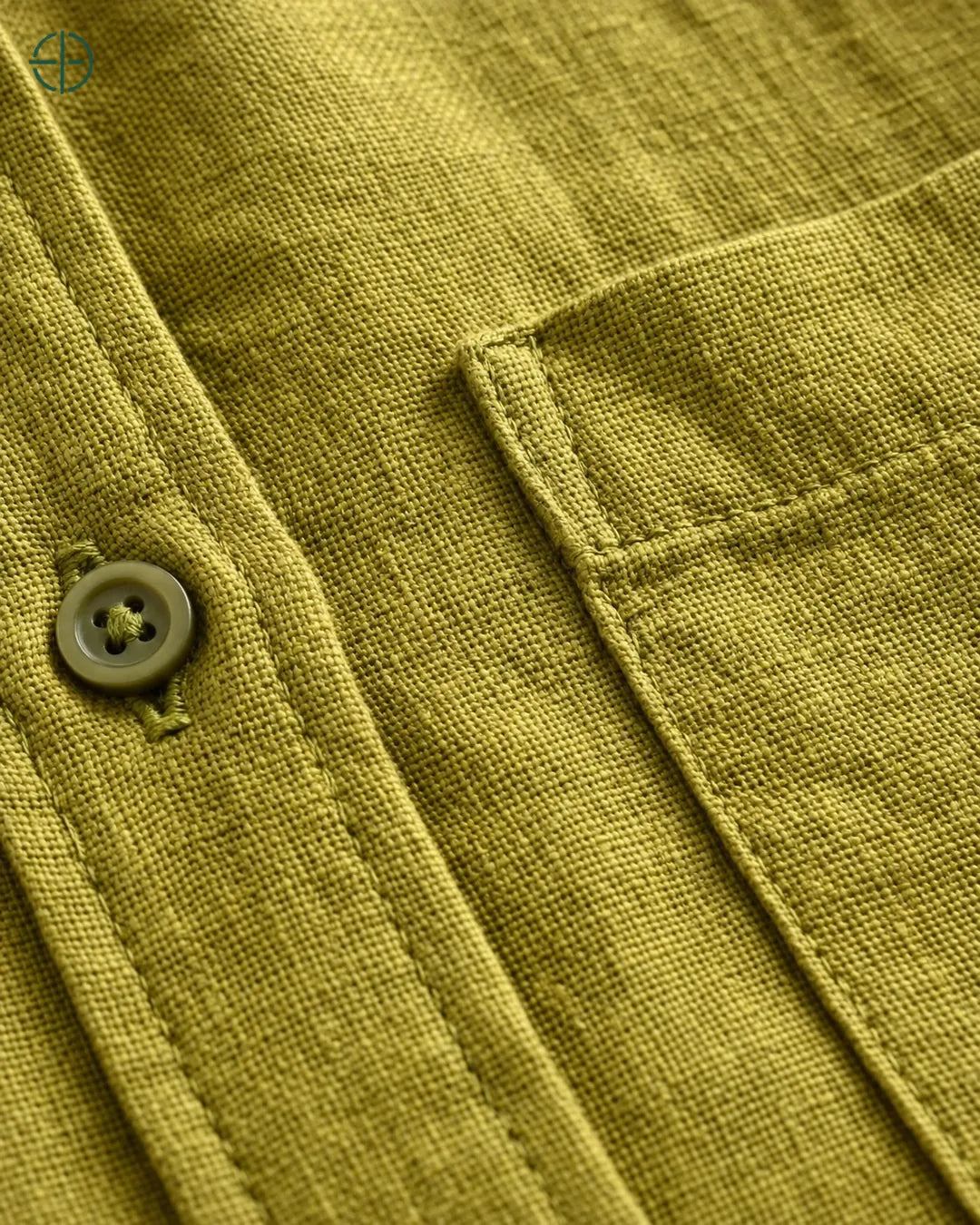 Camisa 100% Linho Belga Masculina, cor Oliva, Detalhe aproximado do tecido e da costura no modelo, mostrando textura real, em estúdio profissional com fundo cinza ostra.