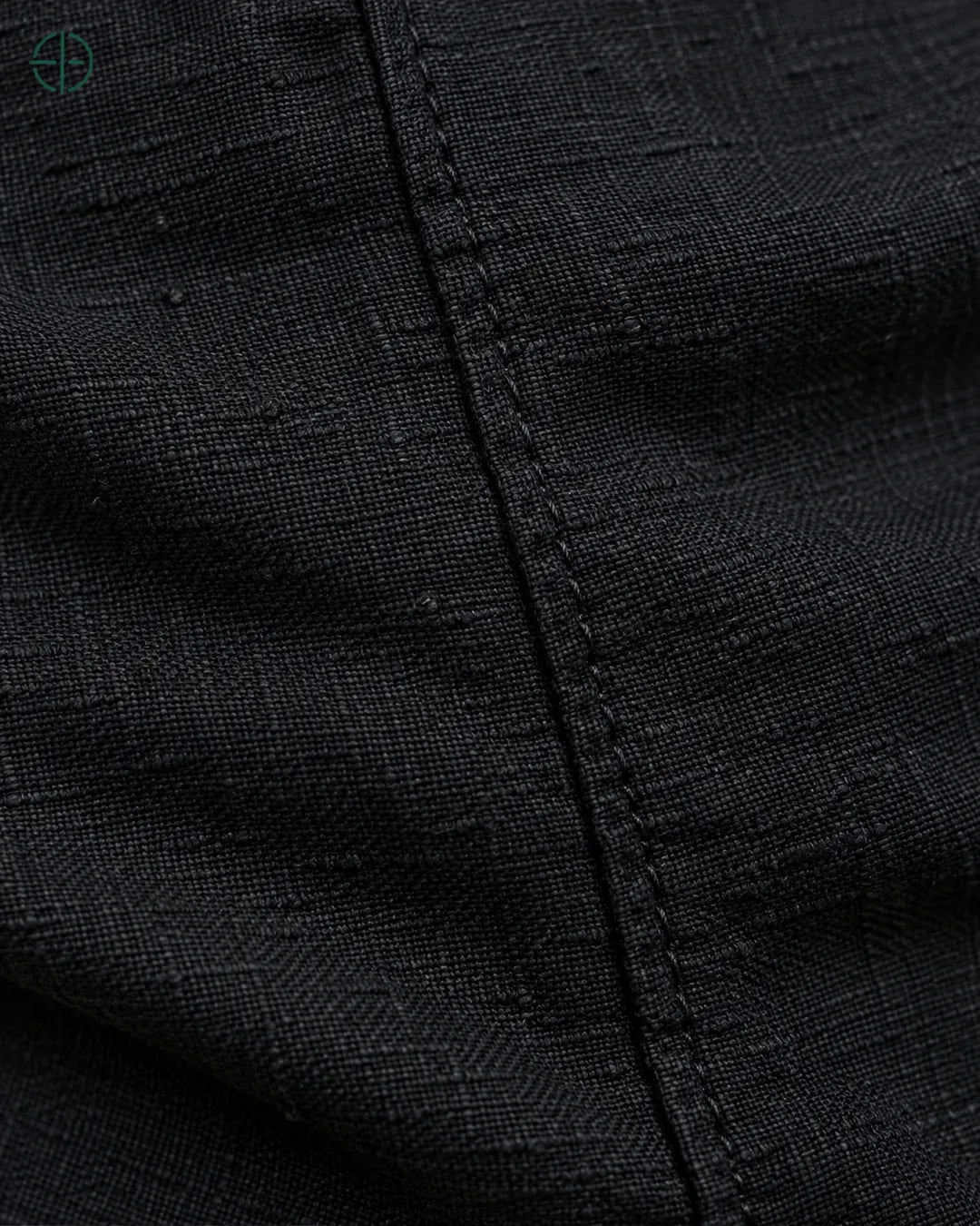 Camisa 100% Linho Belga Masculina, cor Preto, macro do produto no modelo, em estúdio profissional com fundo cinza ostra.
