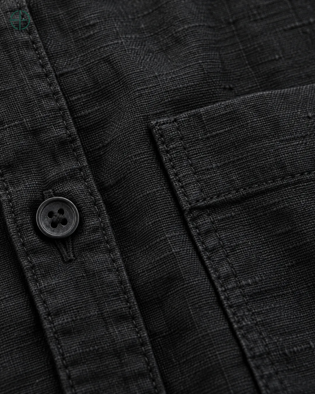 Camisa 100% Linho Belga Masculina, cor Preto, Detalhe aproximado do tecido e da costura no modelo, mostrando textura real, em estúdio profissional com fundo cinza ostra.