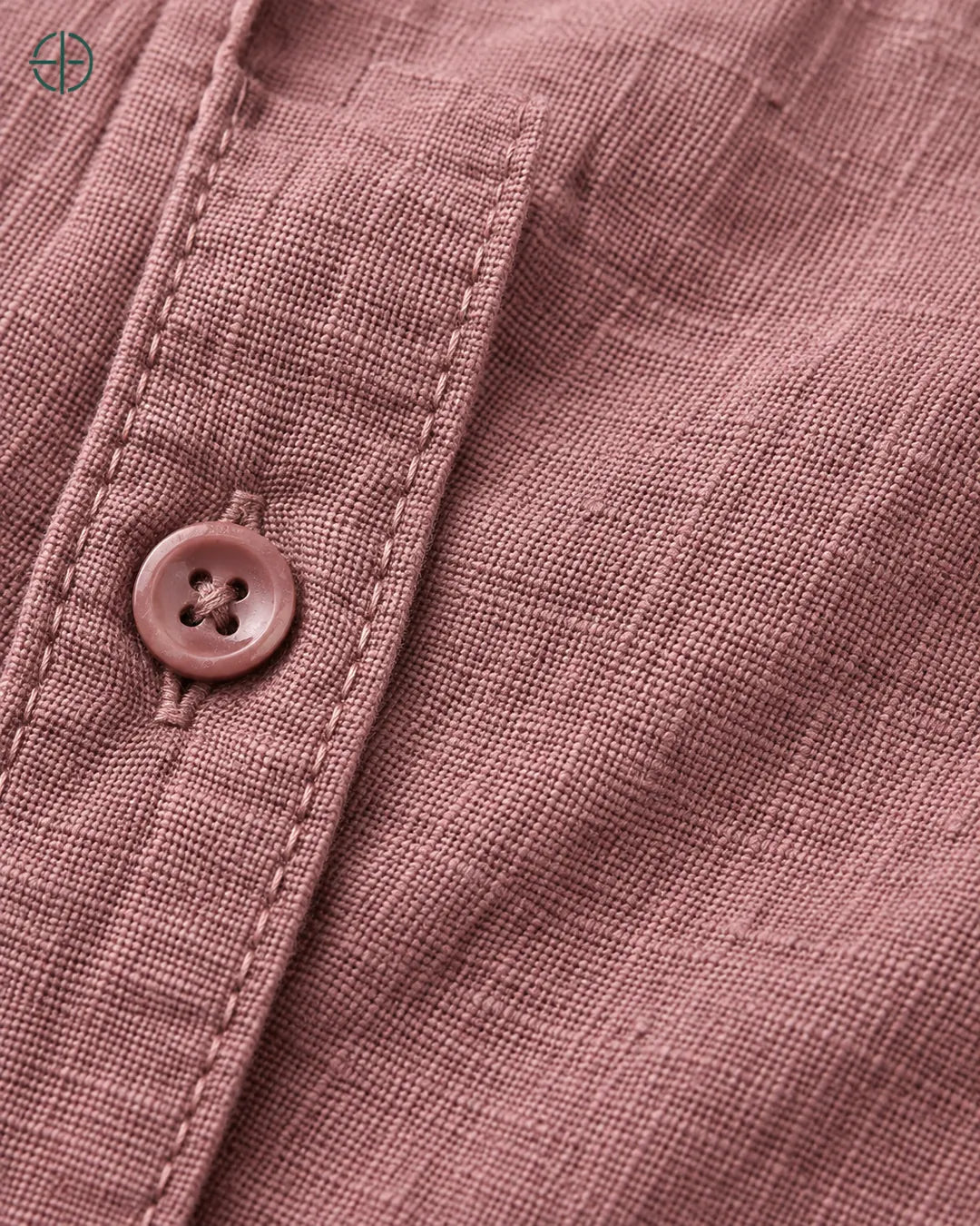 Camisa 100% Linho Belga Masculina, cor Rosa, Detalhe aproximado do tecido e da costura no modelo, mostrando textura real, em estúdio profissional com fundo cinza ostra.