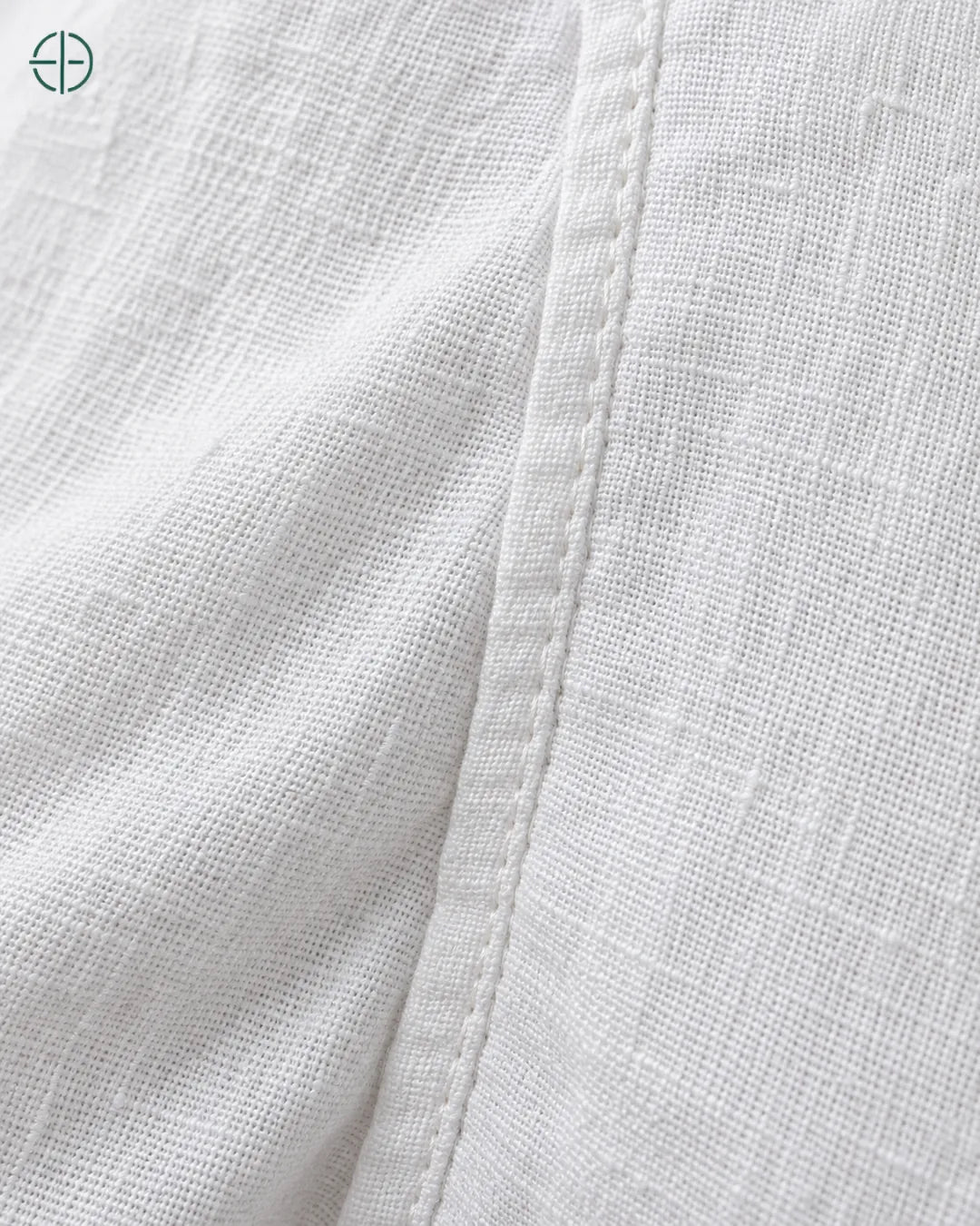 Camisa 100% Linho Belga Masculina Sem Bolso, cor Branco, macro do produto no modelo, em estúdio profissional com fundo cinza ostra.