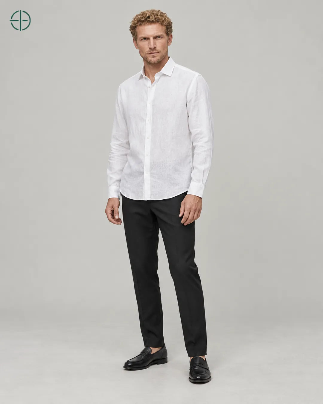 Camisa 100% Linho Belga Masculina Sem Bolso, cor Branco, Mesmo modelo e roupa em pose natural de três quartos, mostrando o caimento da peça, em estúdio profissional com fundo cinza ostra.