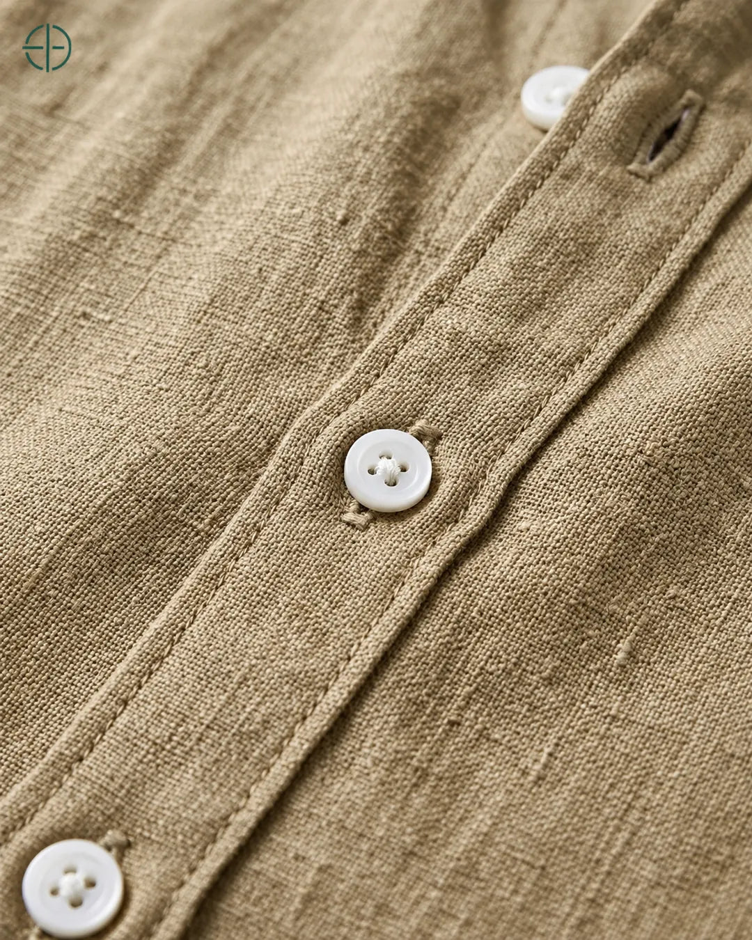 Camisa 100% Linho Belga Masculina Sem Bolso, cor Camelo, Detalhe aproximado do tecido e da costura no modelo, mostrando textura real, em estúdio profissional com fundo cinza ostra.