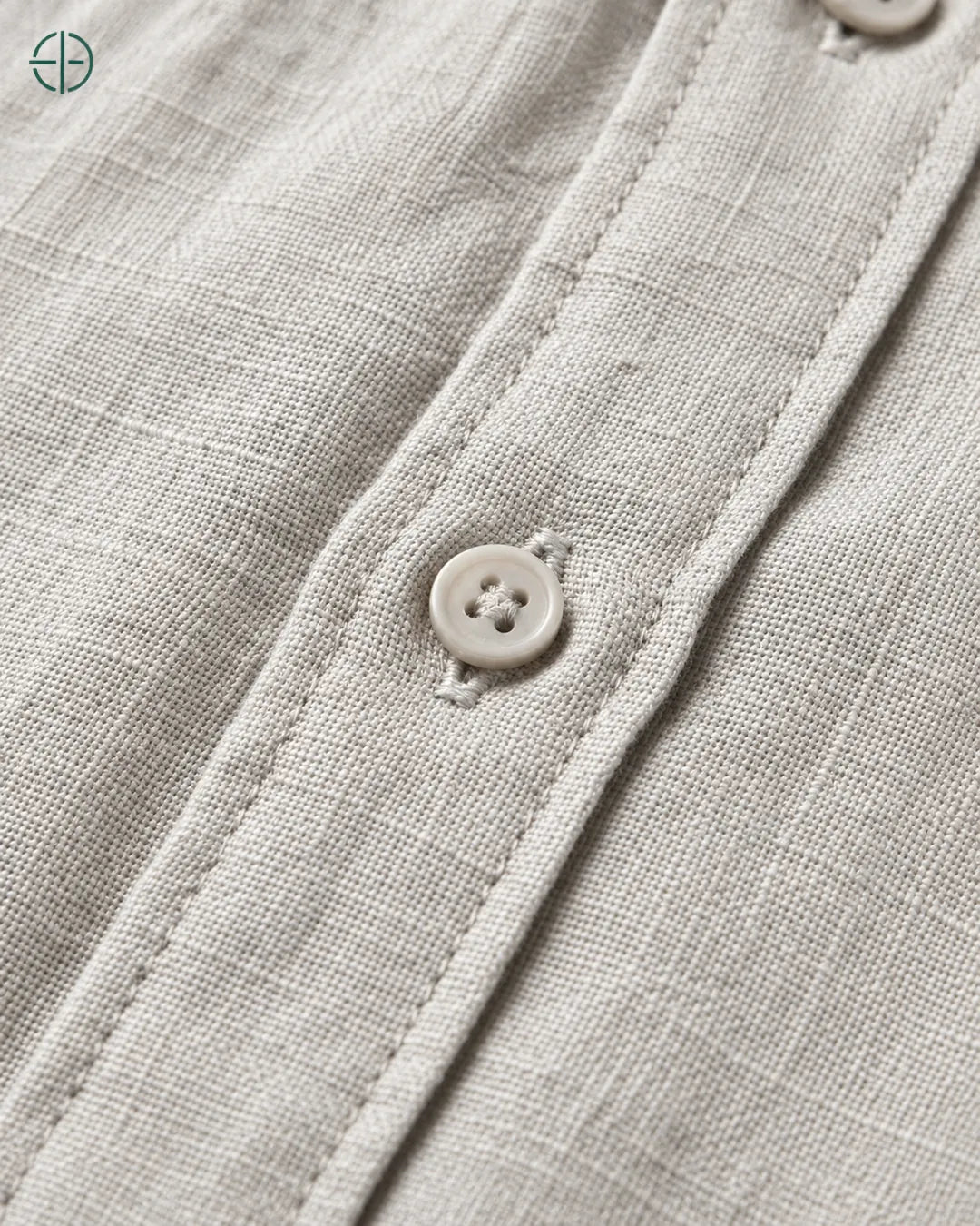 Camisa 100% Linho Belga Masculina Sem Bolso, cor Cinza, Detalhe aproximado do tecido e da costura no modelo, mostrando textura real, em estúdio profissional com fundo cinza ostra.