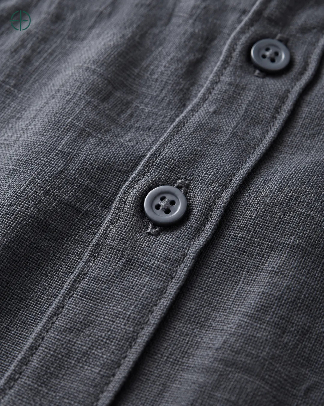 Camisa 100% Linho Belga Masculina Sem Bolso, cor Grisalho, Detalhe aproximado do tecido e da costura no modelo, mostrando textura real, em estúdio profissional com fundo cinza ostra.