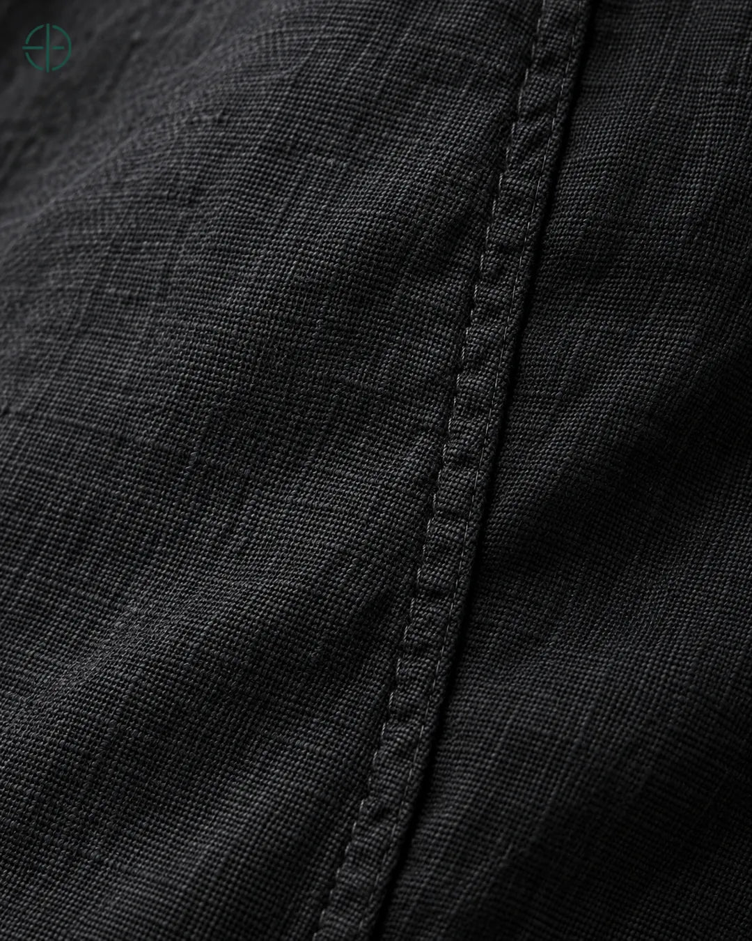 Camisa 100% Linho Belga Masculina Sem Bolso, cor Preto, macro do produto no modelo, em estúdio profissional com fundo cinza ostra.