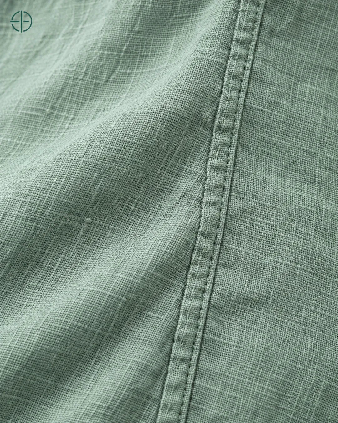 Camisa 100% Linho Belga Masculina Sem Bolso, cor Verde, macro do produto no modelo, em estúdio profissional com fundo cinza ostra.